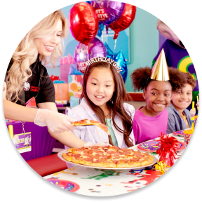 Kids in birthday hats being served pizza