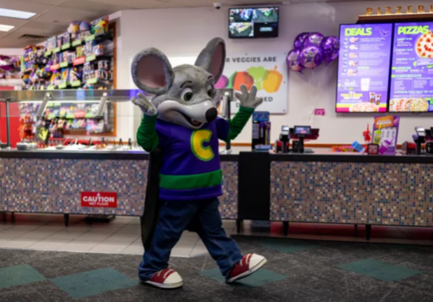 Chuck E. Cheese in front of the salad bar